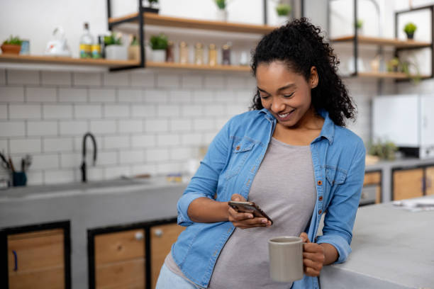 istock Woman relaxing at home texting on her cell phone while drinking coffee 2060737397
