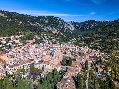 Experience the charm and beauty of Valldemossa in Mallorca through this stunning aerial drone view. Nestled in the hills of the Tramuntana mountain range, this quaint village is a gem of the island, known for its stone streets, traditional houses, and the famous Royal Carthusian Monastery.