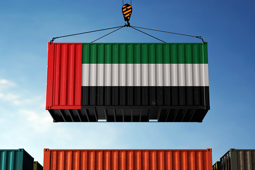 United Arab Emirates (UAE) trade cargo container hanging against clouds background