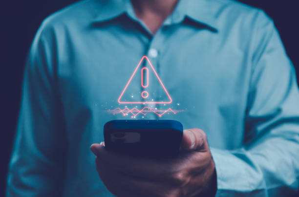istock Businessman using smartphone with caution warning alert symbol, indicating urgent notification or cybersecurity threat sing for error and virus detection spyware, Internet network security concept. 2060748458