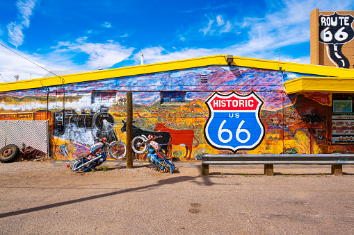 Seligman, Arizona, United States - September 22, 2023:  Mural on Gift Shop and partially buried motorbikes