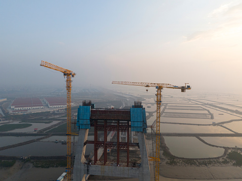 Aerial photo of the under construction cross sea bridge at sunrise