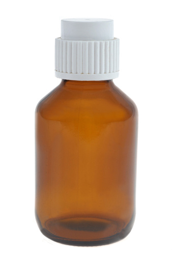Glass bottle with a white plastic cap close-up on a white background