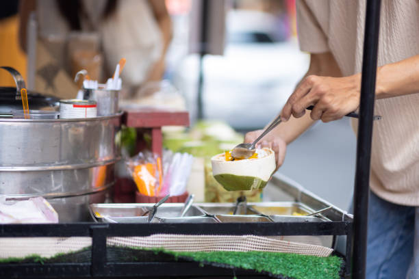 street food thailand. merchant scooping ice cream. asian tourist friends walking on the street market, they are buying delicious ice cream. - women eating ice cream indigenous culture ストックフォトと画像