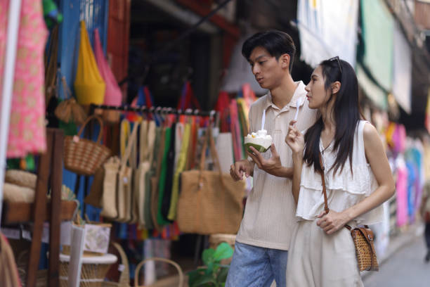 asian tourist friends are walking on the street in the retail market, they are buying delicious ice cream on street food. - women eating ice cream indigenous culture ストックフォトと画像