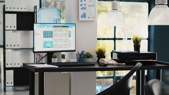 Empty office with stock portfolio on computer monitor containing collection of investment bonds and other financial assets. Real time index indices showing stock demand surge on PC, panning shot