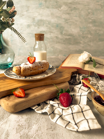 Breakfast with milk, strawberries and a strawberry croissant