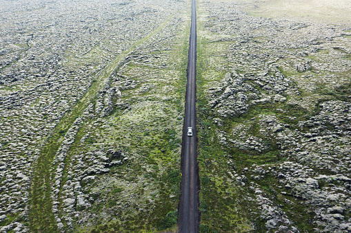 Aerial view on a road through the volcanic landscape in Iceland. Lava field covered with moss.
