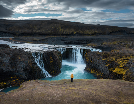 Aerial view on a man standing on the edge of Sigoldufoss in Iceland.