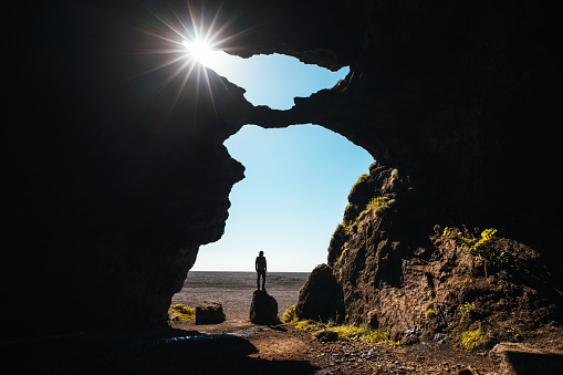 View from the iconic Yoda cave in South Iceland (Hjörleifshöfði). Man standing on the rock.