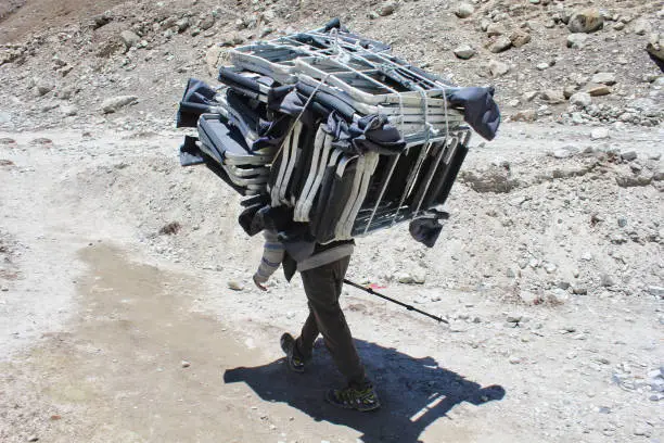 Sherpa Porter carrying a heavy load on the Everest base camp trek trails towards Gorakshep village,Nepal