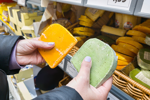 Cheeses in hands on store