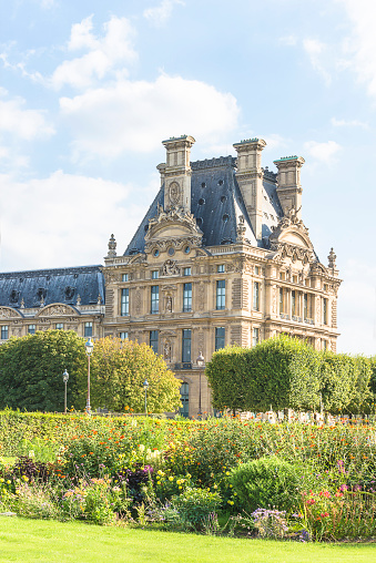 Paris, France; 08.22.2018: Le Louvre building in  bloomingTuileries garden, sunny summer day