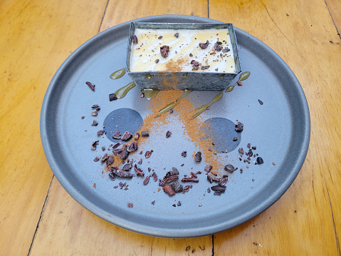Silky panna cotta dessert, artistically served with cocoa powder and cacao nibs, restaurant