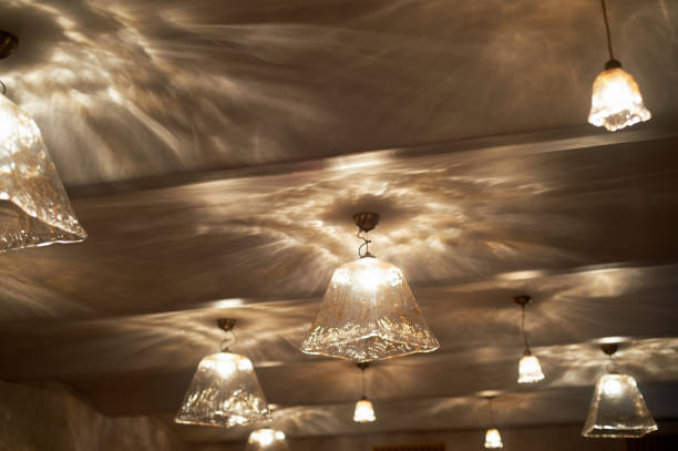 Large glass lamps and glare from them on the ceiling. Warm light