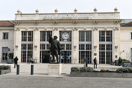 Valence, France-02 21 2024: Statue of  French politician F. D.  Bancel ( 1822- 1871 ) and passengers in front of the Valence - Ville railroad station, France.