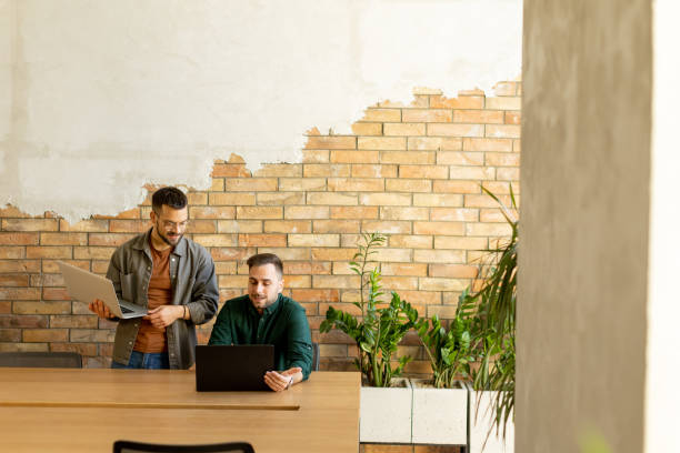 istock Collaboration in Motion, Professionals Working Together in a Modern Brick-Walled Office 2060840371