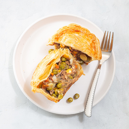 Sliced beef pot pie on plate, top view, square format