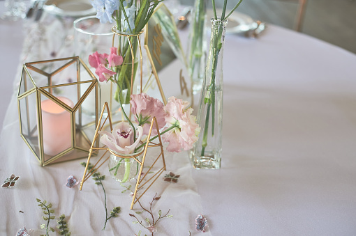 Floristics. Floral decoration of the wedding in pastel colors. Many flowers in different vases and vessels