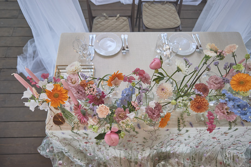 Floristics. Floral decoration of the wedding in pastel colors. Many flowers in different vases and vessels