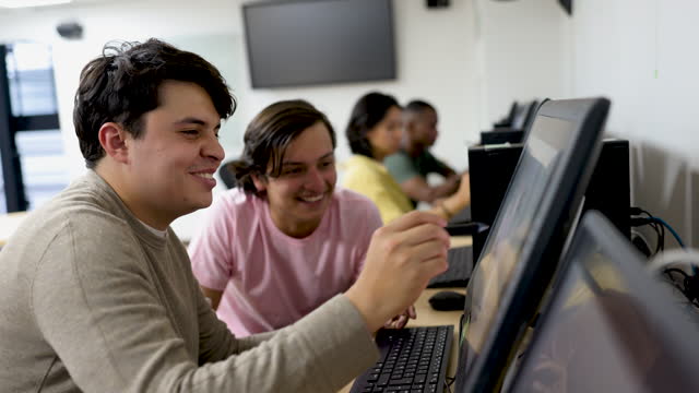 Team of graphic design students retouching a photo on the computer while talking and smiling