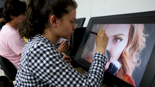 Young female student retouching a photo during class looking very focused