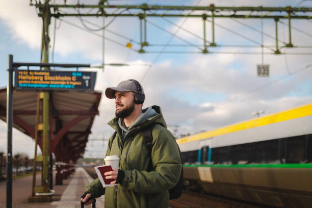 istock Young man waiting for the train at the railroad station 2060887172