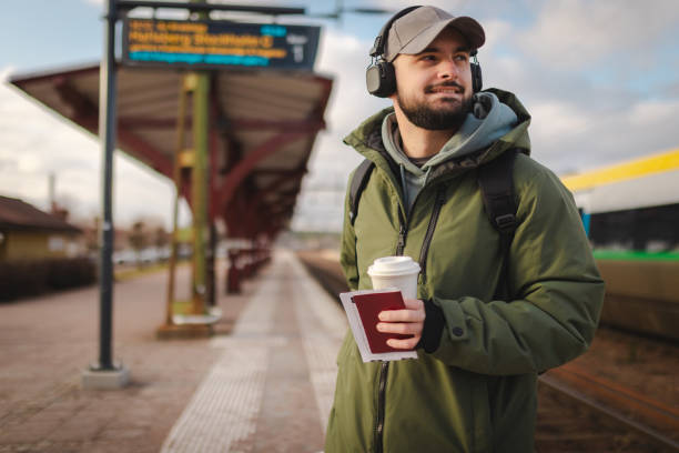 istock Young man waiting for the train at the railroad station 2060887698