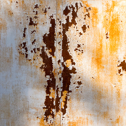 Front view of rusty metal surface with peeling paint