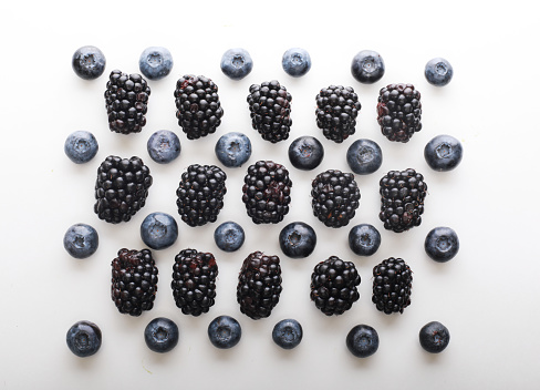 Mix berries patern over white background. Blackberries and blueberries. Close up.