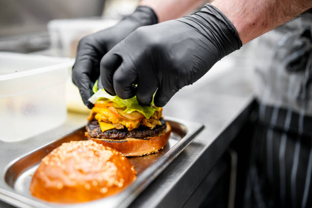 istock chef hand cooking cheese burger on restaurant kitchen 2060899834