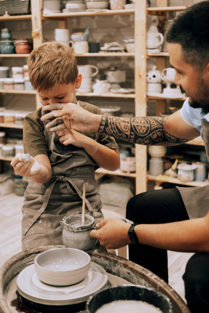 istock Confident young man and little boy making ceramic pot on the pottery class 2060904802