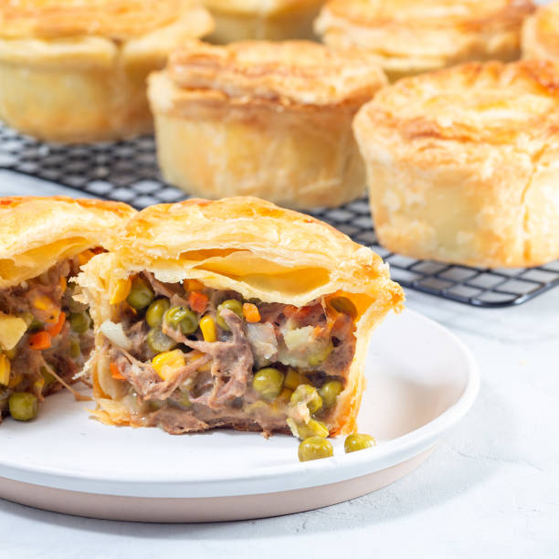 istock Sliced beef pot pie on plate, pies on cooling rack, square 2060906583