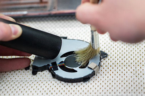 Macro of a brush cleaning a laptop fan