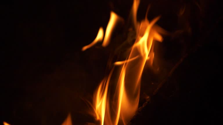 Crackling firewood flames in a campfire, extreme close-up view