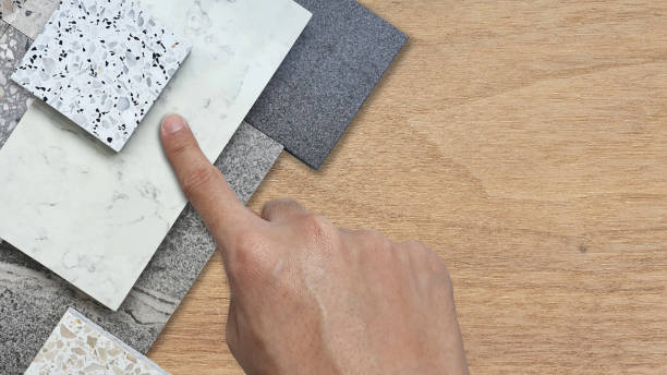 istock interior architect chooses materials sample including terrazzo stones, white marble, grainy ceramic tile, emperador tile placed on wooden table with blank space for design in close up view. 2060972593