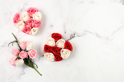 Abstract floral arrangement,beautiful spring roses in boxes with heart,bouquet and gift on marble background,banner,still life with space for text,floral holiday card,selective focus