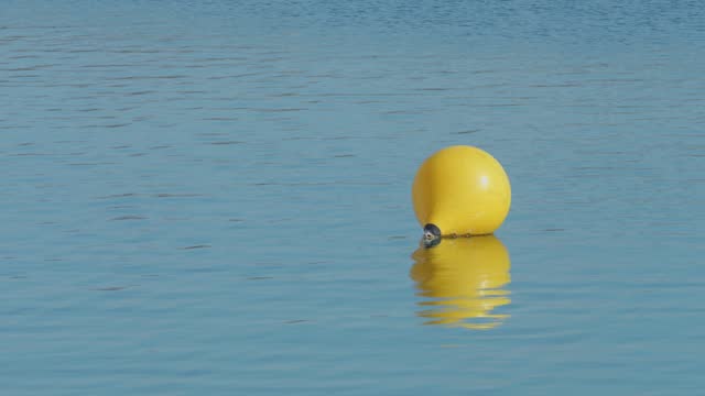 Yellow buoy floating on a calm lake, Jarun Lake, Zagreb, Croatia