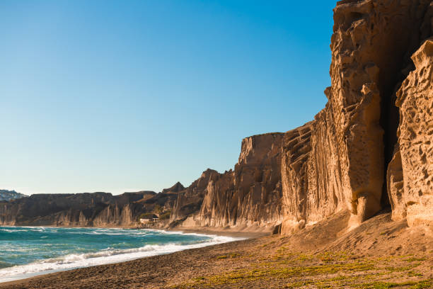 Volcanic cliffs on Vlichada beach, Santorini island, Greece. View of the sea coast at sunny day. stock photo