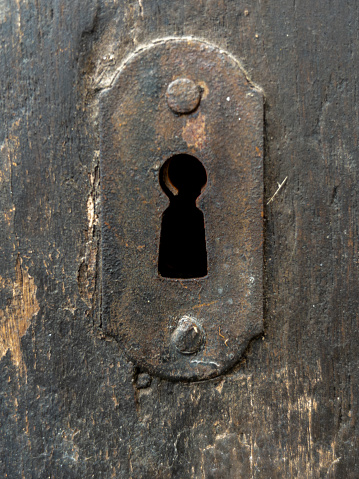 Cloe up of old keyhole on antique wooden door