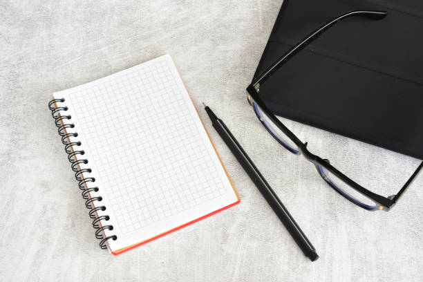 istock lined notepad with pencil, black eye glasses and tablet top view 2061077677