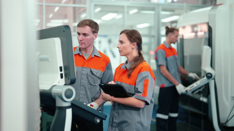 Industrial Precision in Action: Engineering Professionals Operating a CNC Machine in a State-of-the-Art Facility