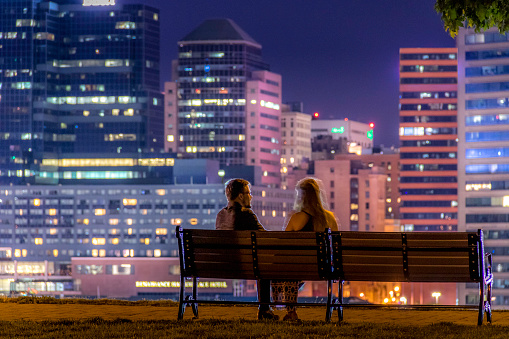 A couple enjoys a romantic evening view overlooking Baltimore’s Inner Harbor at dusk.