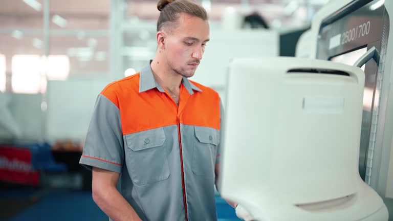 Dedicated Machinist Overseeing CNC Machine Operations in Busy Industrial Manufacturing Environment