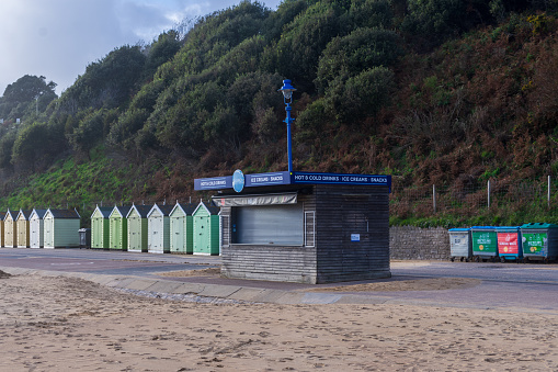 Bournemouth, UK - October 20th 2023: Kiosk and beach huts on the East Beach.