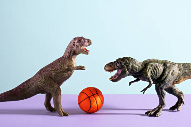 Two dinosaurs playing basketball on blue and violet background.