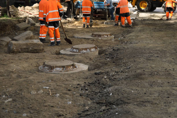 istock Construction site with communal service workers in orange uniform and construction machinery 2061122992