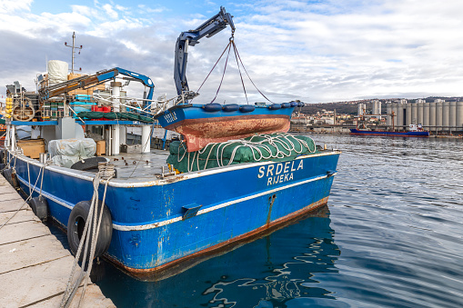 Coverack, Cornwall, UK - July 1, 2021.  The picturesque harbour and village of Coverack in Cornwall with small fishing boats moored on a turquoise ocean.