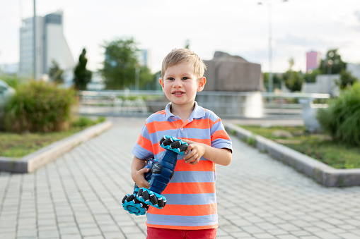 Little boy playing with car on remote control in park