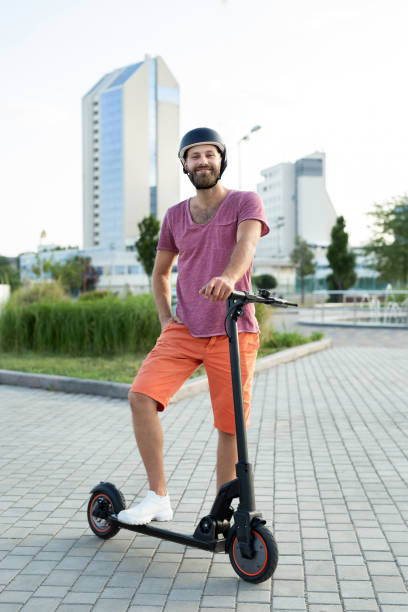 istock Happy man rides an electric scooter in the park. 2061168716
